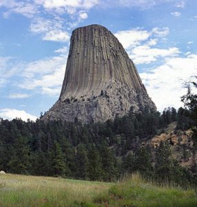 A gray distant view of Devils Tower near dusk